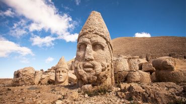 Stone statues on Mount Nemrut in Eastern Turkey under blue sky