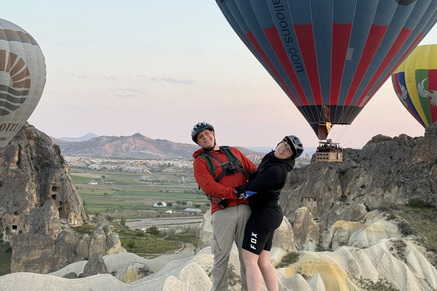 Couple posing in front of hot air balloons during a bike tour in Cappadocia
