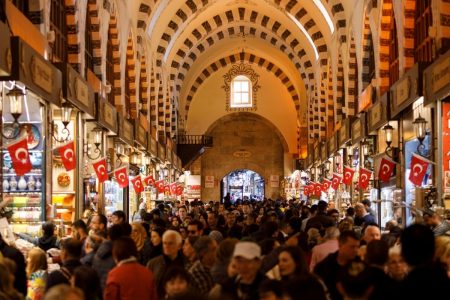 Busy shopping scene inside Istanbul’s Grand Bazaar with Turkish flags and vaulted architecture