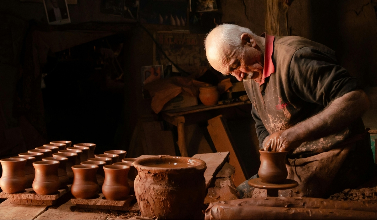 A master potter in Cappadocia working with clay on a traditional wheel, surrounded by freshly made clay pots. This centuries-old craft, especially famous in Avanos, highlights the region’s deep cultural traditions and artisanal skills.